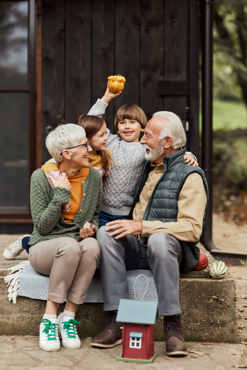 Happy Grandparents And Grandkids Enjoying In Front Of The House.